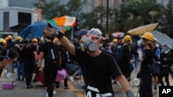 A protester holds a brick during confrontation with police in Hong Kong Monday, Aug. 5, 2019. (AP Photo/Kin Cheung)