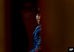 A Chinese relative of passengers aboard a missing Malaysia Airlines plane looks out as she waiting for the latest news inside a hotel room for relatives or friends of passengers aboard the missing airplane in Beijing, China, March 11, 2014.