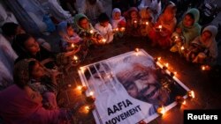 ក្រោម​ការរៀបចំ​របស់​ចលនា Aafia Karachi នៅ​ក្រុង Karachi នៃ​ប្រទេស​ប៉ាគីស្ថាន នៅ​ថ្ងៃ​ទី ០៦ ខែធ្នូ ឆ្នាំ២០១៣ ក្មេងៗ​អង្គុយ​កាន់​ចង្កៀងព័ទ្ធជុំវិញរូប​លោក Nelson Mandela ជា​ការសម្តែង​ការគោរព​ដល់​អតីត​ប្រធានាធិបតី​ប្រទេសអាហ្វ្រិក​ខាង​ត្បូង​រូប​នេះ។