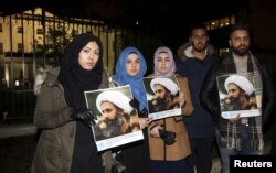 Protesters hold placards as they demonstrate against the execution of prominent Shi'ite cleric Sheikh Nimr al-Nimr outside the Saudi Arabian Embassy in London, Britain, Jan. 2, 2016.