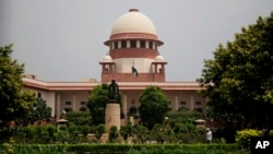 FILE - A gardener works on the lawns of the Supreme Court in New Delhi, India, Aug. 22, 2017. India's Chief Justice of the Supreme Court has presided over a string of verdicts in recent weeks that grant more rights to women, gay couples and religious minorities as he prepares to retire from the bench next month.