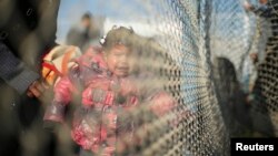 Une enfant palestinienne espère traverser l'Egypte avec sa famille, pleure derrière les barbelés entre l'Egypte et le sud de la bande de Gaza, le 20 janvier 2015.