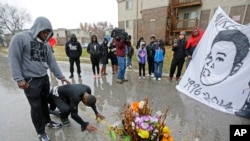 FILE - Ray Mills, left, and Londrelle Hall pause before a memorial for Michael Brown on a street in Ferguson, Mo.