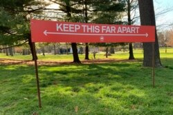 Signage urging social distancing is seen in Prospect Park in the Brooklyn borough of New York, April 8, 2020.
