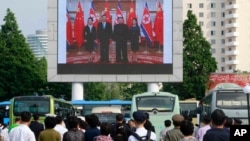 지난 2019년 6월 북한 평양역 광장에 설치된 대형 화면에서 북한 김정은 국무위원장이 중국에서 시진핑 주석 부부와 만난 소식이 나오고 있다. (자료사진)