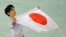 Yuzuru Hanyu of Japan poses with the national flag after he placed first in the men's free skate figure skating final following the flower ceremony at the Iceberg Skating Palace during the 2014 Winter Olympics, Feb. 14, 2014, in Sochi, Russia. 