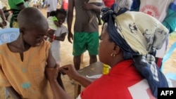 FILE - A child receives a measles vaccine in Nangungue, eastern Cameroon, April 12, 2013.