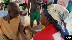 FILE - A child receives a measles vaccine in Nangungue, eastern Cameroon, April 12, 2013.