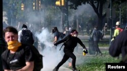 Seorang pengunjuk rasa mengembalikan tabung gas air mata saat berlangsungnya aksi unjuk rasa menentang kematian George Floyd, di Philadelphia, Pennsylvania, 1 Juni 2020.