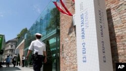 A police guard walks past Palais Coburg where closed-door nuclear talks with Iran will take place in the coming days in Vienna, Austria, June 26, 2015. 