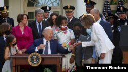 조 바이든(가운데) 미국 대통령이 5일 경찰관 훈장 수여 법안에 서명한 뒤 낸시 펠로시 하원의장에게 펜을 전달하고 있다.