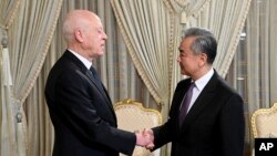 Tunisian President Kais Saied, left, shakes hands with Chinese Foreign Minister Wang Yi on Jan. 15, 2024, in Tunis. (Tunisian Presidency via AP)