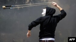 Un manifestant palestinien jetant une pierre à la police israélienne près de la prison d’Ofer, le 4 avril 2014.