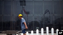 File - Solar panels at a factory in Baoding, in northern China's Hebei province. China, the world's largest polluter of climate changing emissions, is aggressively adopting solar energy to cut its dependence on fossil fuels.