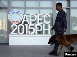 A military personnel walks past an APEC logo with his sniffer dog at the media center of the Asia-Pacific Economic Cooperation (APEC) summit in the capital city of Manila, Philippines November 17, 2015.