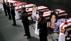FILE - Honor guard stand in front of caskets prior to a memorial service for first responders who died in the fertilizer plant explosion in West, Texas, April 25, 2013, in Waco, Texas.