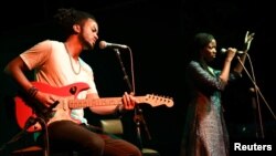 Guitarist Brahim Wone and singer Awa Ly perform on stage at the Saint Louis Jazz Festival in Saint Louis, Senegal, June 18, 2021. (REUTERS/Cooper Inveen)