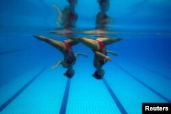 FILE - Brazil's synchronized swimmers Maria Eduarda Miccuci (R) and Luisa Borges perform during a photo session at the Rio Olympic Park in Rio de Janeiro, Brazil, April 29, 2016.