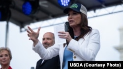 资料照片：美国农业部长罗林斯与商务部长卢特尼克等官员在华盛顿的美国农业部总部前发表讲话。(2025年8月6日)