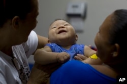 FILE - Caio Julio Vasconcelos, who was born with microcephaly, undergoes physical therapy at the Institute for the Blind in Joao Pessoa, Brazil, Feb. 25, 2016.