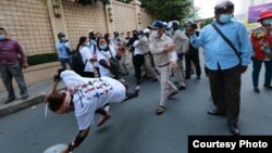 រូបឯកសារ៖ អ្នកស្រី ​សេង ចាន់ថន​​ អាយុ៤៩ឆ្នាំ ​ត្រូវបាន​ចាប់បោកផ្ទប់​ទៅនឹង​ថ្នល់ដោយ​កម្លាំង​សន្ដិសុខខណ្ឌ ​ខណៈដែល​កំពុងតវ៉ា​ដោយសន្តិវិធី​ប្រឆាំងនឹង​ការចាប់ខ្លួន​ស្វាមី​របស់អ្នកស្រី នៅរាជធានីភ្នំពេញ ថ្ងៃទី ៤ ខែកញ្ញា ឆ្នាំ២០២០។ (រូបថតដោយលីកាដូ)