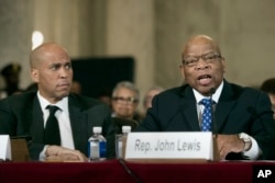 Sen. Cory Booker, D-N.J., listens at left as Rep. John Lewis, D-Ga. testifies on Capitol Hill in Washington, Jan. 11, 2017, at the second day of a confirmation hearing for Attorney General-designate, Sen. Jeff Sessions, R-Ala., before the Senate Judiciary Committee.