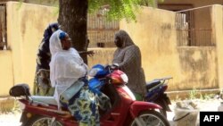 FILE - Women chatting while sitting on their bikes in a district of Maroua, northern Cameroon.