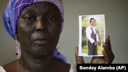 Martha Mark, ibu dari Monica Mark yang diculik Boko Haram, memperlihatkan foto putrinya di rumahnya di Chibok, Nigeria. (AP/Sunday Alamba)