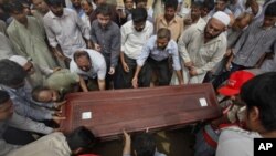 Relatives and colleagues carry the casket of Pakistani journalist Saleem Shahzad for burial after funeral prayers in Karachi, June 1, 2011