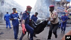 Petugas penyelamat Nigeria mengangkut korban tewas dalam ledakan bom di sebuah mall yang ramai di Abuja, Rabu (25/6). 