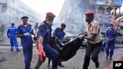 25일 나이지리아 수도 아부자의 한 상가에서 폭탄테러가 발생해 20여명이 사망한 가운데, 구조대원들이 부상자를 옮기고 있다.