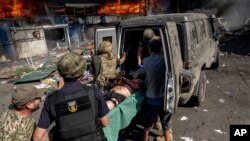 امدادگران در حال کمک به مجروحان پس از حمله موشکی روسیه به یک بازار مواد غذایی - کوستیانتینیوکا، اوکراین.