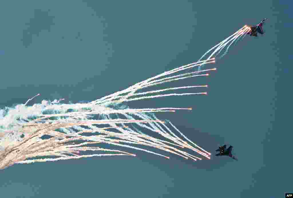 Tim aerobatik Rusia melakukan demonstrasi terbang Sukhoi SU-27 pada hari keempat Aero India 2013 di markas Angkatan Udara Yelahanka di Bangalore, India. 