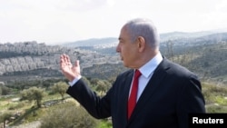 PM Israel Netanyahu memberikan keterangan dengan latar belakang pemukiman Israel Har Homa, di daerah Tepi Barat yang diduduki Israel, 20 Februari 2020. (Foto: dok).