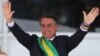 FILE - Brazil's new President Jair Bolsonaro gestures after receiving the presidential sash from outgoing President Michel Temer at the Planalto Palace, in Brasilia, Brazil, Jan. 1, 2019. 
