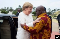 German Chancellor Angela Merkel, left, is welcomed by Ghana's President, Nana Akufo-Addo, right, at the Presidential palace in Accra, Ghana, Aug 30, 2018.