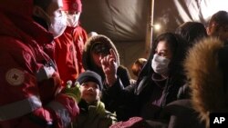 30일 벨라루스-폴란드 국경 인근에서 적십자 요원들이 이민자들과 대화하고 있다.