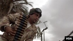 Seorang tentara Libya di kota Benghazi sedang mengisi amunisi senjatanya, Sabtu (26/2).
