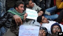 Tunisian protesters who walked from Sidi Bouzid, lay on the ground in front of the prime minister building in Tunis, 23 Jan 2011