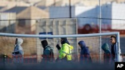 FILE - Teen migrants walk in line inside the Tornillo detention camp in Tornillo, Texas, Dec. 13, 2018. 