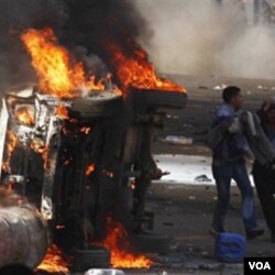 Para demonstran membakar mobil dan gedung-gedung dalam protes di Kairo Jumat (28/1).