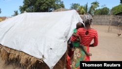 A woman, called Elsa by UK-based aid group Save the Children, walks with a child in a displacement camp in the northern Mozambique province of Cabo Delgado, Mozambique.