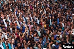 Supporters of Bilawal Bhutto Zardari, chairman of the Pakistan People's Party, wave as they listen to his speech, during a campaign rally ahead of general elections in District Thatta, Pakistan, July 2, 2018.