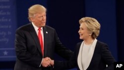Kandidat presiden AS dari Partai Demokrat Hillary Clinton dan lawannya dari Partai Republik, Donald Trump, bersalaman setelah melakukan debat kepresidenan kedua di Washington University, St. Louis (9/10). (AP/Patrick Semansky)