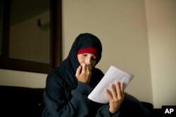 FILE - Kimberly Polman, a Canadian national, reads a letter at camp Roj in Syria, April 3, 2019.