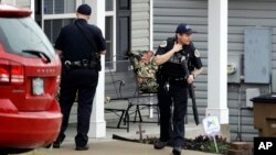 Nashville police officers search a neighborhood near a Waffle House restaurant, April 22, 2018, in Nashville, Tennessee, site of a deadly shooting early Sunday. The shooter is still on the lose.