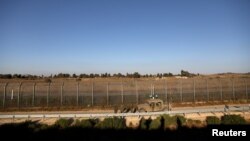 FILE - Israeli soldiers patrol the cease-fire line between Israel and Syria, as seen from the Israeli-occupied Golan Heights, July 26, 2018.