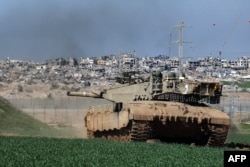 Di sepanjang perbatasan dengan Jalur Gaza pada 18 Januari 2024, terlihat tank Israel meluncur di sepanjang pagar dan merusak bangunan di Gaza. (Foto: AFP)