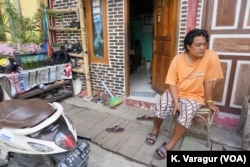 Community organizer Gugun Muhammad sits outside a sustainable pilot house in Kampung Tongkol, Indonesia.