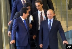Japanese Prime Minister Shinzo Abe, left, and Russian President Vladimir Putin come down on the escalator after their talks in Vladivostok, Russia, Friday, Sept. 2, 2016.